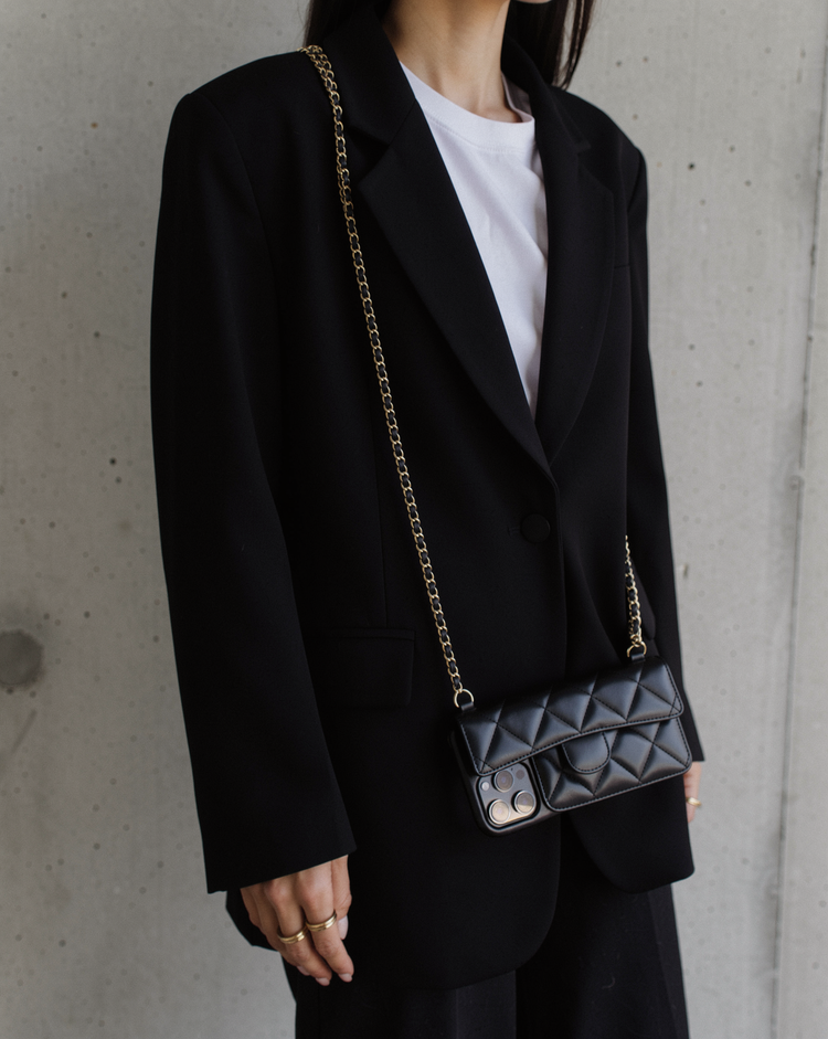 Black quilted phone case worn crossbody